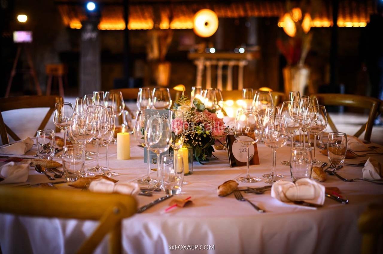 Location salle Maligny (Côte-d'Or) - Domaine du Grand Nanteux #5 Table élégamment dressée avec nappes blanches, verres à vin, bougies et centre de table floral dans une ambiance chaleureuse.