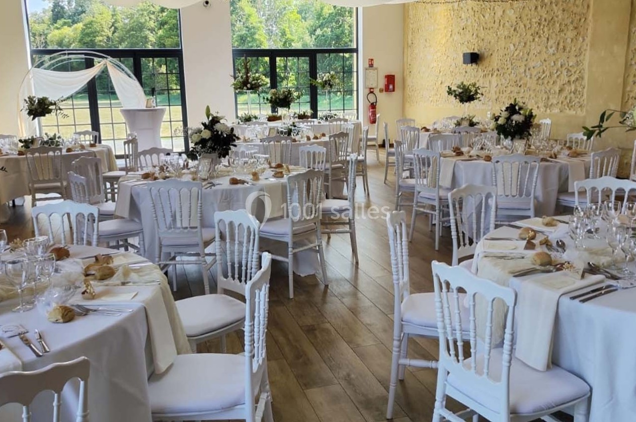 Location salle Sylvains-les-Moulins (Eure) - Domaine de Coulonge #16 Salle de réception décorée pour un mariage, avec tables rondes dressées, nappes blanches et arrangements floraux.