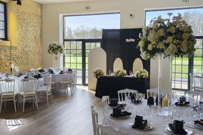 Miniature Location salle Sylvains-les-Moulins (Eure) - Domaine de Coulonge #7 Salle de réception décorée avec des tables rondes, nappes blanches, chaises blanches et centres de table fleuris.