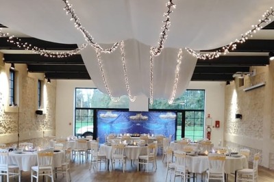 Miniature Location salle Sylvains-les-Moulins (Eure) - Domaine de Coulonge #8 Salle de réception décorée avec des tables rondes, nappes blanches, chaises blanches et centres de table fleuris.