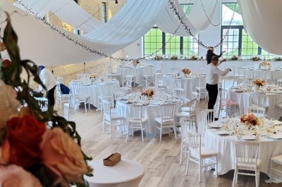 Miniature Location salle Sylvains-les-Moulins (Eure) - Domaine de Coulonge #6 Salle de réception décorée avec des tables rondes, nappes blanches, chaises blanches et centres de table fleuris.