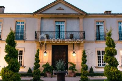 Miniature Location salle Lançon-Provence (Bouches-du-Rhône) - La Bastide d'Astres #5 Vue d'une terrasse avec parasols et piscine, encadrée par des haies sombres et un ciel dégagé en arrière-plan.