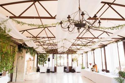 Miniature Location salle Lançon-Provence (Bouches-du-Rhône) - La Bastide d'Astres #4 Vue d'une terrasse avec parasols et piscine, encadrée par des haies sombres et un ciel dégagé en arrière-plan.