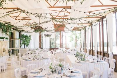 Miniature Location salle Lançon-Provence (Bouches-du-Rhône) - La Bastide d'Astres #3 Vue d'une terrasse avec parasols et piscine, encadrée par des haies sombres et un ciel dégagé en arrière-plan.