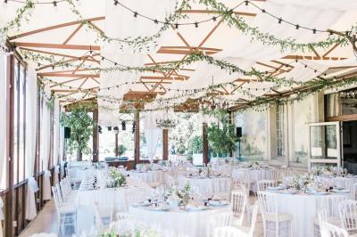 Miniature Location salle Lançon-Provence (Bouches-du-Rhône) - La Bastide d'Astres #2 Vue d'une terrasse avec parasols et piscine, encadrée par des haies sombres et un ciel dégagé en arrière-plan.