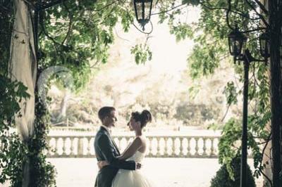 Miniature Location salle Lançon-Provence (Bouches-du-Rhône) - La Bastide d'Astres #17 Vue d'une terrasse avec parasols et piscine, encadrée par des haies sombres et un ciel dégagé en arrière-plan.