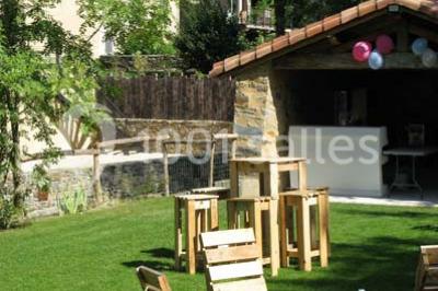 Petit ruisseau bordé de végétation avec des tentes blanches installées pour un événement en arrière-plan.