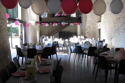 Petit ruisseau bordé de végétation avec des tentes blanches installées pour un événement en arrière-plan.