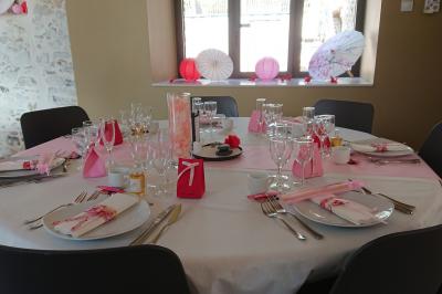 Petit ruisseau bordé de végétation avec des tentes blanches installées pour un événement en arrière-plan.