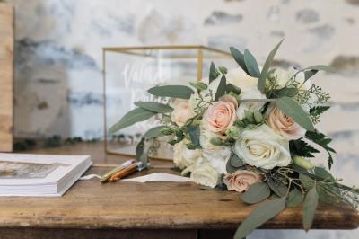 Petit ruisseau bordé de végétation avec des tentes blanches installées pour un événement en arrière-plan.