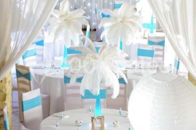 Stand en bois avec des boissons, verres et décorations tropicales, sous une pancarte ’Bar à cocktail’.