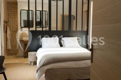 Stand en bois avec des boissons, verres et décorations tropicales, sous une pancarte ’Bar à cocktail’.