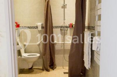 Stand en bois avec des boissons, verres et décorations tropicales, sous une pancarte ’Bar à cocktail’.