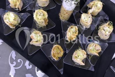 Miniature Location salle Sartrouville (Yvelines) - Salle Neila #30 Cuillères transparentes disposées en cercle sur une assiette noire, remplies de semoule garnie de légumes et herbes.