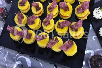 Miniature Location salle Sartrouville (Yvelines) - Salle Neila #31 Cuillères transparentes disposées en cercle sur une assiette noire, remplies de semoule garnie de légumes et herbes.