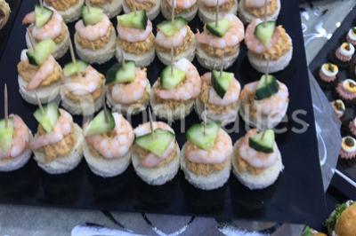 Miniature Location salle Sartrouville (Yvelines) - Salle Neila #32 Cuillères transparentes disposées en cercle sur une assiette noire, remplies de semoule garnie de légumes et herbes.