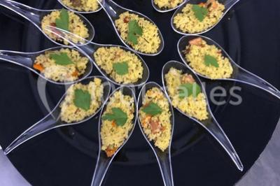 Miniature Location salle Sartrouville (Yvelines) - Salle Neila #34 Cuillères transparentes disposées en cercle sur une assiette noire, remplies de semoule garnie de légumes et herbes.