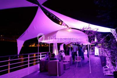 Miniature Location salle Paris 5 (Paris) - La Péniche Notre Dame de Paris #12 Personnes dansant dans une salle faiblement éclairée avec des lumières colorées créant une ambiance festive.