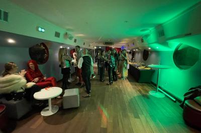 Miniature Location salle Paris 5 (Paris) - La Péniche Notre Dame de Paris #29 Personnes dansant dans une salle faiblement éclairée avec des lumières colorées créant une ambiance festive.