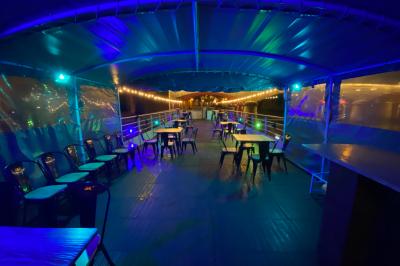 Miniature Location salle Paris 5 (Paris) - La Péniche Notre Dame de Paris #11 Personnes dansant dans une salle faiblement éclairée avec des lumières colorées créant une ambiance festive.