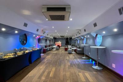 Miniature Location salle Paris 5 (Paris) - La Péniche Notre Dame de Paris #30 Personnes dansant dans une salle faiblement éclairée avec des lumières colorées créant une ambiance festive.