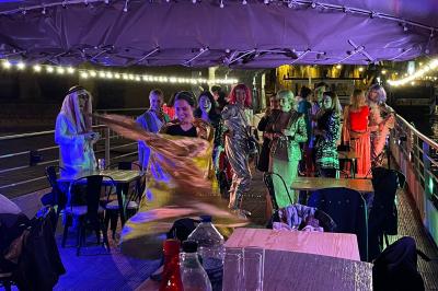 Miniature Location salle Paris 5 (Paris) - La Péniche Notre Dame de Paris #7 Personnes dansant dans une salle faiblement éclairée avec des lumières colorées créant une ambiance festive.