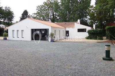 Un jardin verdoyant avec pelouse, arbres, arbustes et une charrette ancienne près d'un abri en bois.