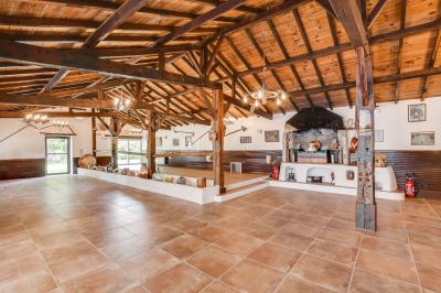 Un jardin verdoyant avec pelouse, arbres, arbustes et une charrette ancienne près d'un abri en bois.