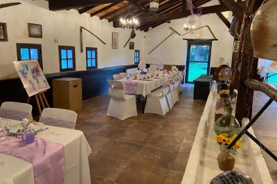 Un jardin verdoyant avec pelouse, arbres, arbustes et une charrette ancienne près d'un abri en bois.