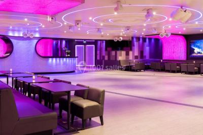 Miniature Location salle Paris 16 (Paris) - Le Duplex #2 Entrée d'un espace moderne avec éclairage bleu, tapis rouge et panneau lumineux affichant un logo.