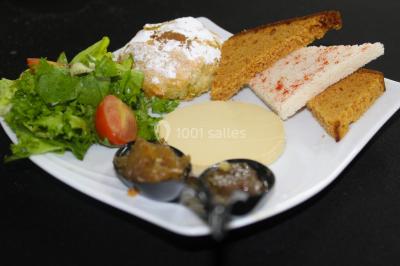 Assiette composée de riz safrané garni d'amandes et raisins secs, jarret d'agneau en sauce et accompagnements.
