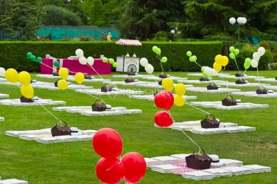 Miniature Location salle Le Port-Marly (Yvelines) - Les Pyramides #20 Tables rondes dressées avec nappes bleues alignées sur une pelouse, entourées d'arbres, avec un parc en arrière-plan.