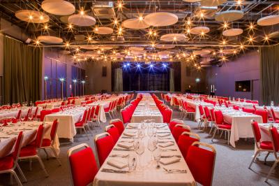 Dessert en forme de cœur au chocolat sur une assiette blanche, accompagné de coulis rouge et d'une verrine en arrière-plan.