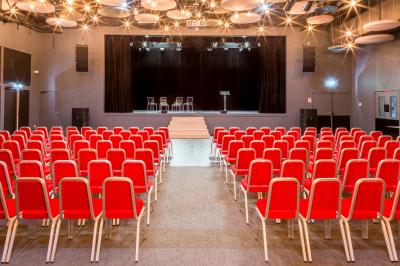 Dessert en forme de cœur au chocolat sur une assiette blanche, accompagné de coulis rouge et d'une verrine en arrière-plan.