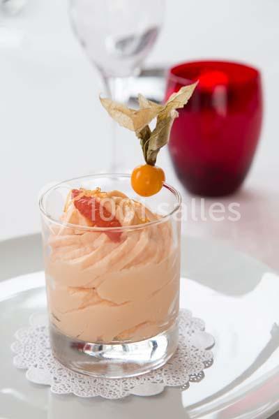 Location salle La Roche-Posay (Vienne) - Casino de la Roche Posay #16 Mousse orange servie dans un verre, décorée d'un physalis et d'un segment de pamplemousse, posée sur une napperon blanc.
