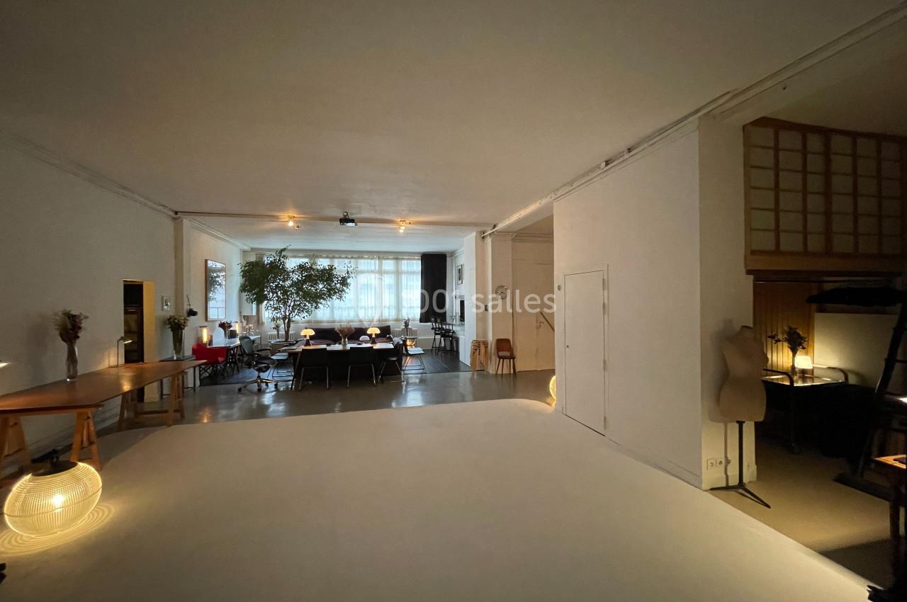 Espace intérieur spacieux avec un grand plateau blanc, des meubles modernes et une lumière naturelle abondante.