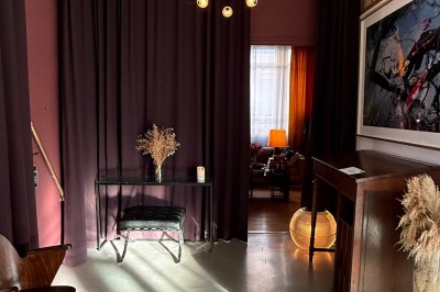 Miniature Location salle Paris 20 (Paris) - Studio 7 #25 Grand arbre en pot éclairé par une lumière verte dans un salon moderne avec canapé, tables et vases de fleurs.