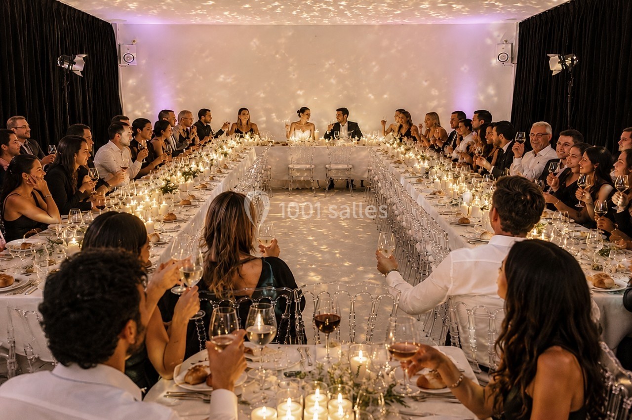 Location salle Paris 20 (Paris) - Studio 7 #9 Salle de réception éclairée par des bougies, avec des invités assis autour de longues tables en U.