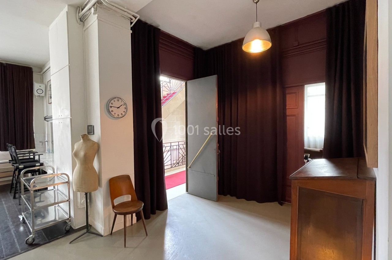 Location salle Paris 20 (Paris) - Studio 7 #48 Espace intérieur avec un mannequin de couture, une chaise, un meuble en bois et une porte ouverte sur un escalier.