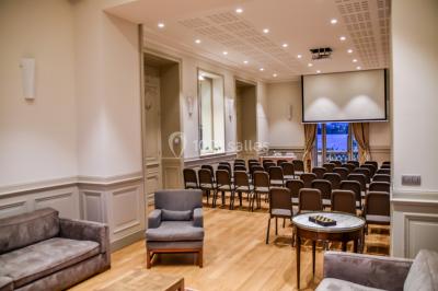 Montgolfière en cours de gonflage sur une pelouse, avec un manoir en arrière-plan et des arbres environnants.