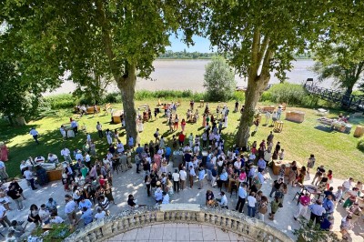 Montgolfière en cours de gonflage sur une pelouse, avec un manoir en arrière-plan et des arbres environnants.