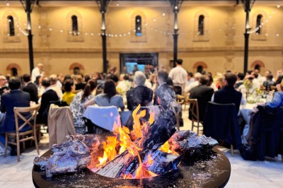 Montgolfière en cours de gonflage sur une pelouse, avec un manoir en arrière-plan et des arbres environnants.