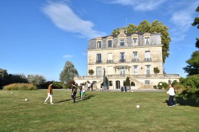 Montgolfière en cours de gonflage sur une pelouse, avec un manoir en arrière-plan et des arbres environnants.