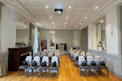 Montgolfière en cours de gonflage sur une pelouse, avec un manoir en arrière-plan et des arbres environnants.