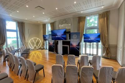 Montgolfière en cours de gonflage sur une pelouse, avec un manoir en arrière-plan et des arbres environnants.