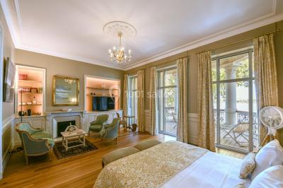 Montgolfière en cours de gonflage sur une pelouse, avec un manoir en arrière-plan et des arbres environnants.