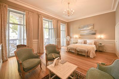 Montgolfière en cours de gonflage sur une pelouse, avec un manoir en arrière-plan et des arbres environnants.