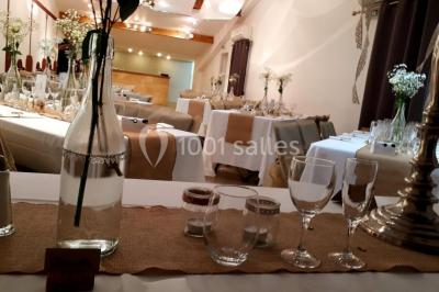 Salle lumineuse avec murs blancs et rouges, sol en carrelage beige, poutres apparentes et comptoir en pierre au fond.