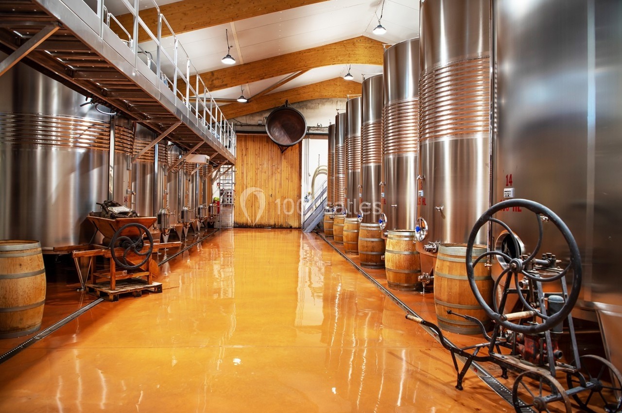 Location salle Rognes (Bouches-du-Rhône) - Domaine Naïs #5 Salle de production vinicole avec cuves en acier inoxydable, tonneaux en bois et équipements traditionnels.