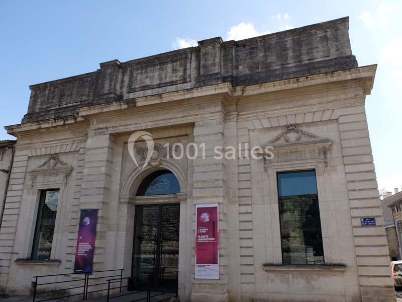 Location salle Avignon (Vaucluse) - Le Grenier à Sel #2 Façade d'un bâtiment en pierre avec une entrée centrale voûtée et des affiches sur les côtés.